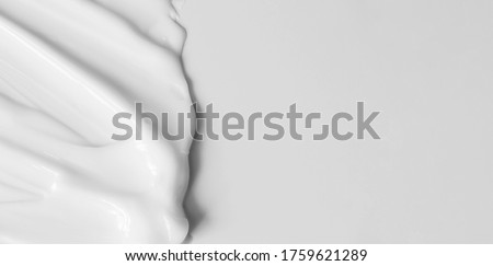 Close-up cream moisturiser smear smudge wavy texture on white background with copy space horizontal banner format. Skin care beauty product