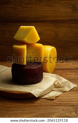 composition of different types of sliced cheese: hard, mature, cheese with mold. Cheese slicing with fruit - grapes and figs. concept is cheese handicraft production