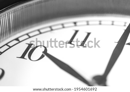 Clock hand pointing ten o'clock on white clock face of Twin bell classic alarm clock