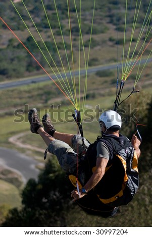 Paraglider jumping off hill and in the air just after lift off