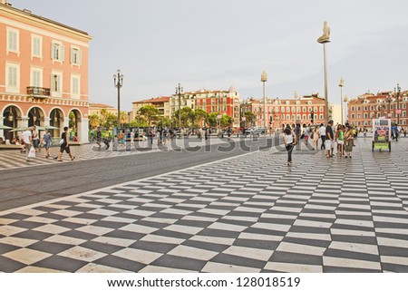 NICE, FRANCE - AUGUST 20: Tourists walking in the Place Massena, on August 20, 2011 in Nice, France. The place is the most famous of the city because of its beauty, shopping options and the carnival.