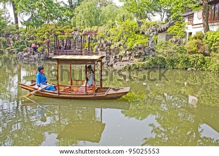 SUZHOU, CHINA - APRIL 26: Artist playing music on a boat in the Lion Grove Garden on April 26, 2011 in Suzhou, China. This garden is recognized as a UNESCO World Heritage Site.