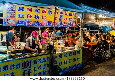 TAIPEI, TAIWAN - JULY 14: Hungry crowds eat at the Shilin Night Market food court in the Shilin District of Taipei July 14, 2013. Shilin Market is the most popular and largest night market in Taiwan.