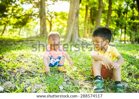 two brothers sitting in green grass