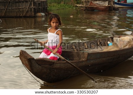 KOMPONG PHLUK, CAMBODIA - CIRCA DECEMBER 2014: Boat as a single means of transport for a young girl in a remote water village.
