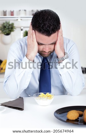 Businessman with headache at breakfast