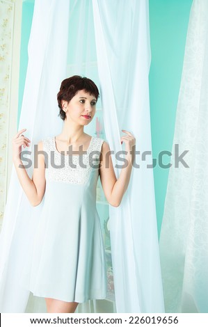 the image of the girl of the curtain standing near