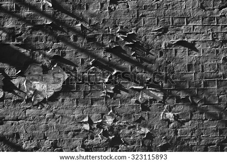 Aged peeled brick wall texture with strong shadows.