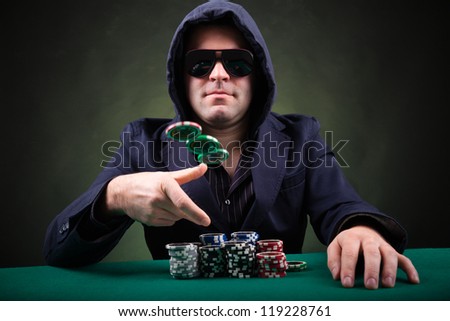 Poker player throwing poker chips on black background