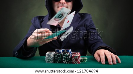 Poker player throwing cards on black background