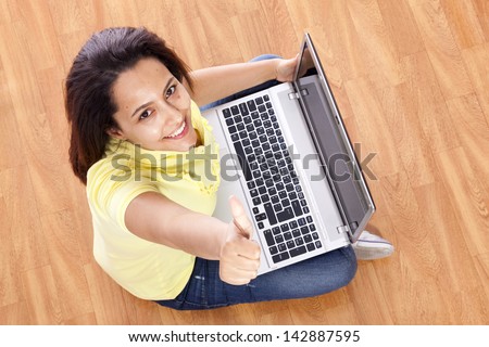smiling young woman thumb up with laptop working at home