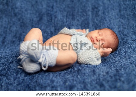 Newborn baby boy sleeping on blue blanket