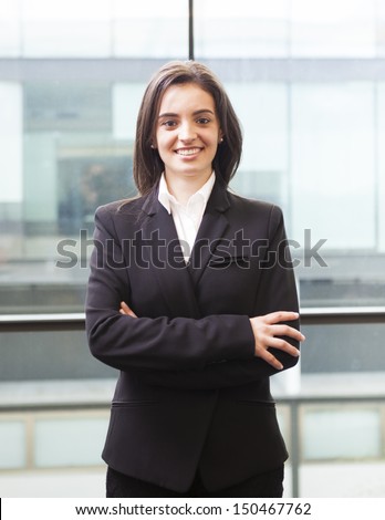 Portrait of a happy smiling young business woman with cross-armed