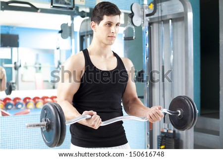 Handsome man lifting heavy free weights at the gym
