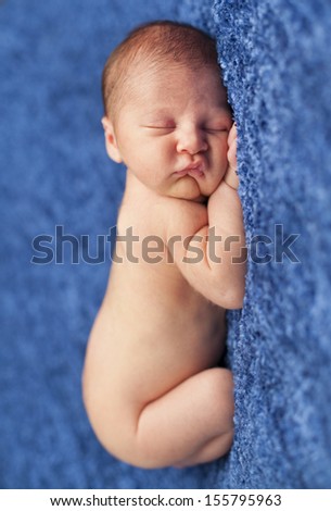 Little newborn baby boy sleeping in a blue blanket