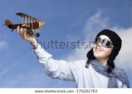 Happy kid playing with toy airplane outdoors