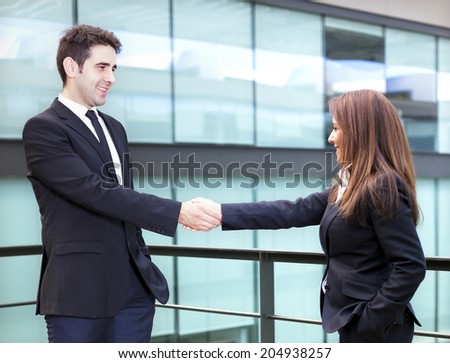 Business partners shaking hands in meeting hall