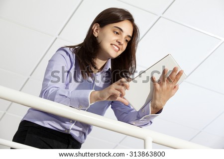 Business woman standing with a tablet computer at the lobby office