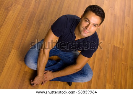 young casual man sitting on the floor at home
