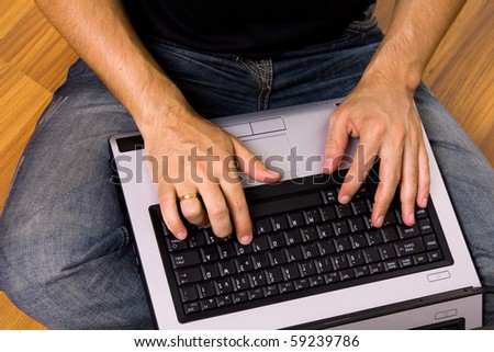 man sitting on the floor working on laptop computer at home