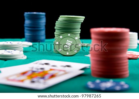 Poker chips and cards on a green felt