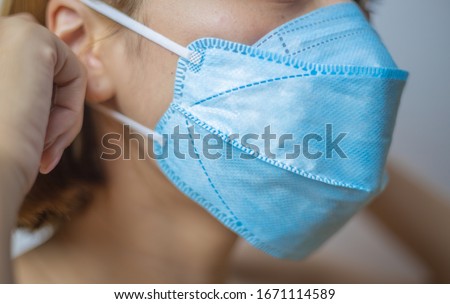 Woman wearing a hygiene protective mask to protect COVID19 virus and pm2.5 pollution while traveling in the crowded place. Woman use face mask to protect corona virus crisis in Asian country. Sickness