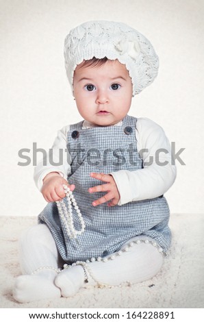 Sweet girl in a beret with a beads in hands