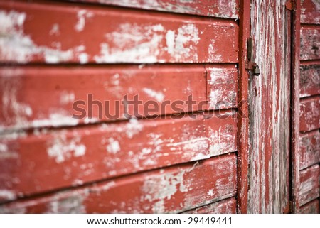 Locked door on an old building with peeling paint. Selective focus drawing the eye to the lock and allowing for copy space.