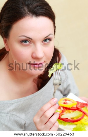 Portrait of young woman with salad at home