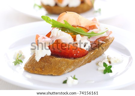 Sandwich with ham, fresh peach and soft goat cheese on white plate
