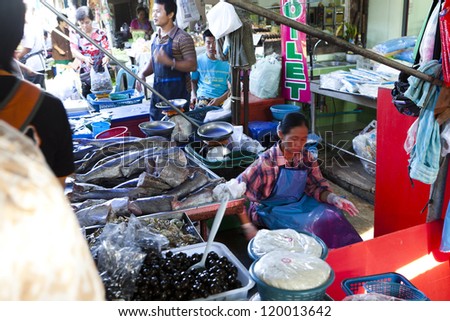MAEKLONG, THAILAND-AUGUST 5:Unidentified people sell food at Maeklong famous railway markets in Maeklong, Thailand on Aug. 5, 2012. The train runs three times a day the train runs through these stalls