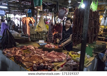 SIEM REAP, CAMBODIA-SEPT 19: Local butchers cutting meat for sale in  Siem Reap, Cambodia on September 19th, 2013, Siem Reap, Cambodia. These local local; butchers are plying their trade in the market