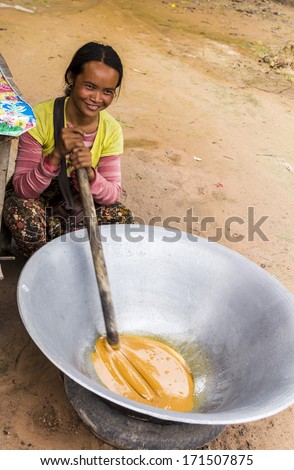 SIEM REAP, CAMBODIA- SEPT 20: The roadside trade in palm sugar Siem Reap, Cambodia, September 20th  2013, Siem Reap, Cambodia, The young girl slowly renders down the sap to make palm sugar