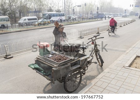 BEIJING, CHINA-MARCH 2014:-The street vendor selling hot roast chestnuts China, March 2014 in Beijing. The street vendors do not rely on high tech stores to hawk their wares.