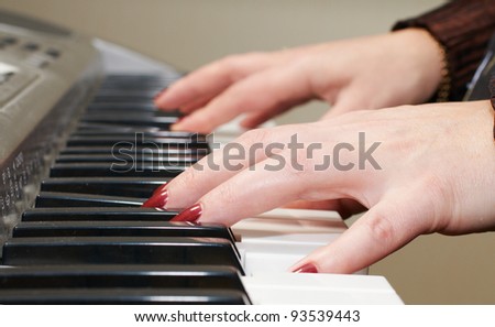 Close up of the hands of a woman playing piano