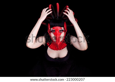 Beautiful young woman with red futuristic face mask