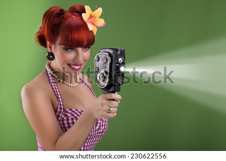 Beautiful redhead pin up girl with vintage camera