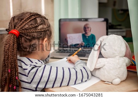 Pretty stylish schoolgirl studying math during her online lesson at home, social distance during quarantine, self-isolation, online education concept