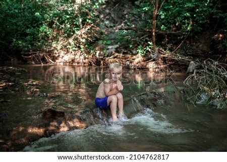 Happy boy swimming under waterfall in stream canyon river in the mountains, nature pool. Cold water, hardening and natural spa procedure, wildlife and green tourism, summer holidays Photo stock © 