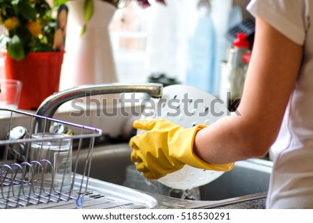 Woman washing dishes in the kitchen. Close up of  woman hand. Housewife clean dishes. Stock foto © 