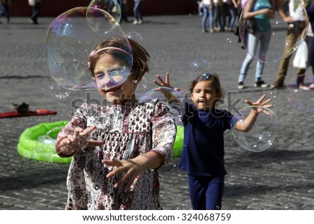 ROME, ITALY - OCTOBER 03 2015: Kids playing with the soap bubbles outdoor  in Rome, Italy
