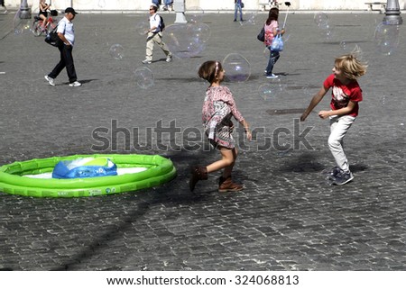 ROME, ITALY - OCTOBER 03 2015: Kids playing with the soap bubbles outdoor  in Rome, Italy