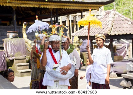 BALI - OCTOBER 17: Balinese priest and  people walk in traditional dress during Funeral procession at Besakih complex on October 17, 2011 in Bali, Indonesia.