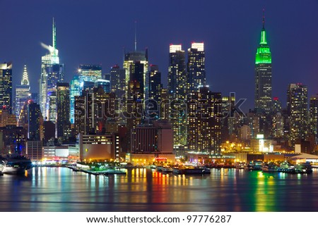 New York City midtown skyline at night over Hudson river