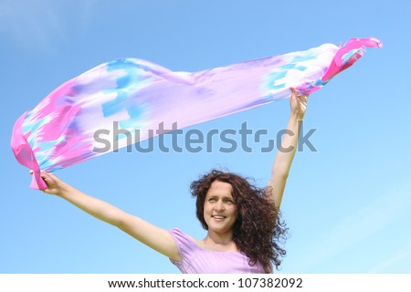 Beautiful ginger Girl With violet Scarf over Blue Sky. Freedom Concept