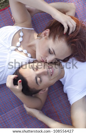 20 years old man and woman relaxing and lying down in a meadow