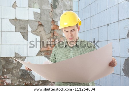 architect looking on the plan of the new building to be built on the site of the old ruins