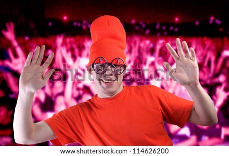 young party-goer in orange dress makes signs with his hands - peace brother - show must go on