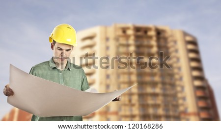 view of architect looking comparing housing project with building