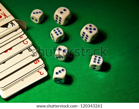 The dice and playing cards on green broadcloth